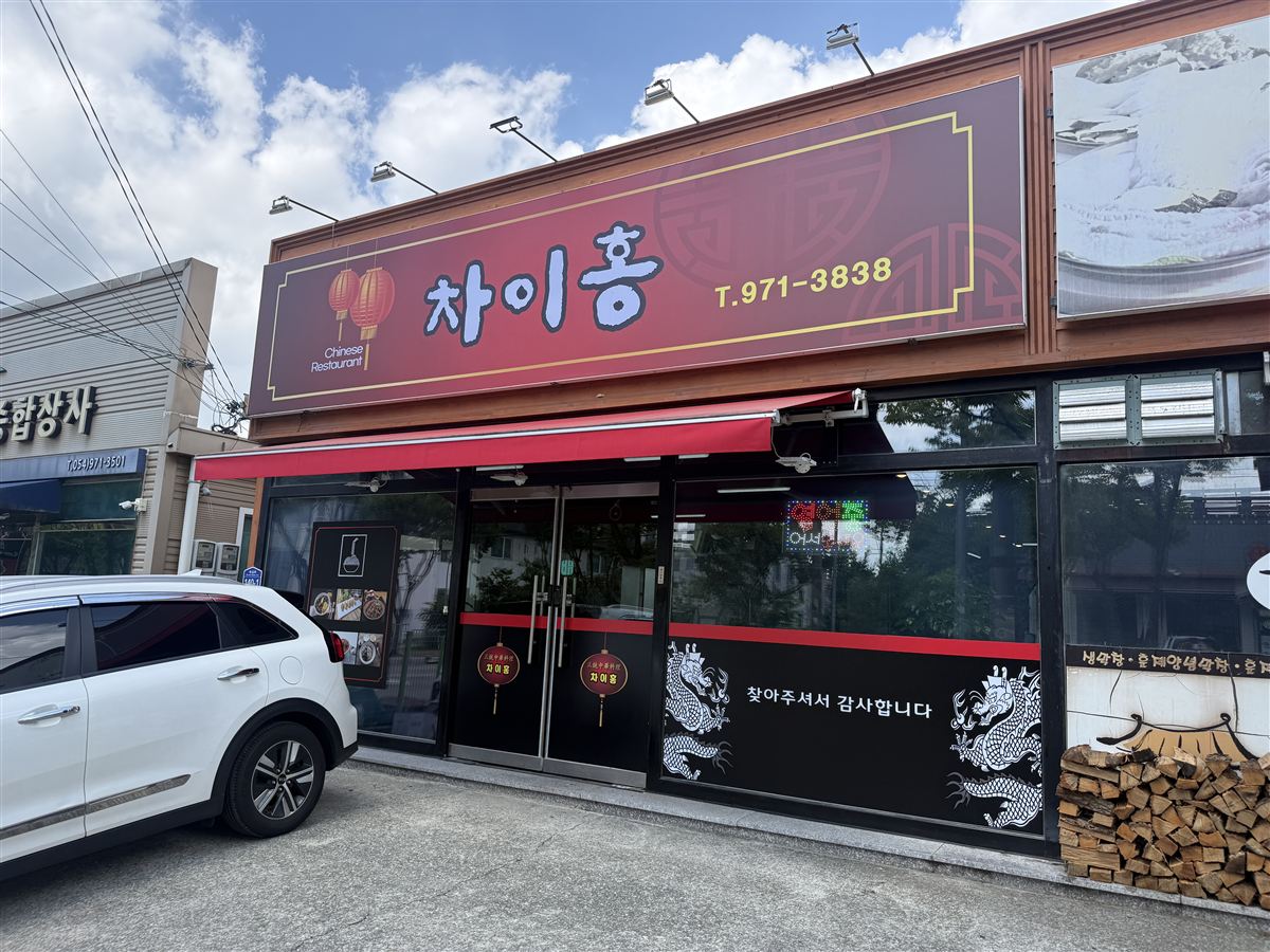 차이홍 매장 외관 — 붉은 간판과 매장 앞 주차 공간